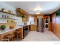 Well-equipped kitchen with stainless steel appliances, open shelving, and breakfast bar, designed for culinary enthusiasts at 4580 Balsam St, Wheat Ridge, CO 80033