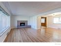 Spacious living room with hardwood floors and fireplace flowing into adjacent rooms at 4580 Balsam St, Wheat Ridge, CO 80033