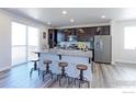 Modern kitchen with stainless steel appliances, dark wood cabinets, granite countertops, and a spacious island with seating at 4783 S Wenatchee Cir, Aurora, CO 80015