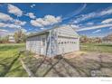 Exterior view of the detached garage with a white door and siding in a fenced yard at 5335 Allison St, Arvada, CO 80002