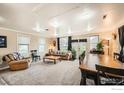Bright living room featuring plush carpeting, a large dining table, and comfortable seating at 5335 Allison St, Arvada, CO 80002