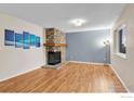 Bright living room featuring hardwood floors, a stone fireplace, and ample natural light at 6221 Willow Ln, Boulder, CO 80301