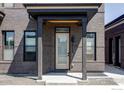 Close-up of a modern townhome entrance featuring a covered porch and stylish door at 859 30Th St, Denver, CO 80205
