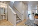 Bright entryway with hardwood floors, a staircase with carpeted steps, and a view into the dining area at 1031 Turnberry Cir, Louisville, CO 80027