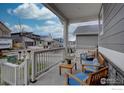 Inviting front porch featuring stylish seating, a small table, and serene views of the neighborhood street at 1031 Turnberry Cir, Louisville, CO 80027
