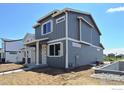 Contemporary two-story home boasts gray siding, white trim, and well-lit porch at 1039 Spartan Ave, Berthoud, CO 80513
