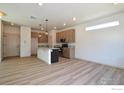 Bright kitchen with island, granite countertops, modern appliances, and wood-look flooring at 1039 Spartan Ave, Berthoud, CO 80513