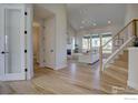 Open-concept living room showcasing hardwood floors, natural light, staircase, and modern decor at 1041 Turnberry Cir, Louisville, CO 80027