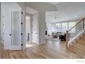 Open-concept living space with hardwood floors, a staircase, and a view of the outdoor area at 1041 Turnberry Cir, Louisville, CO 80027