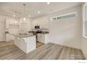 Modern kitchen with a center island, granite countertops, stainless steel appliances, and ample cabinet space at 1043 Spartan Ave, Berthoud, CO 80513