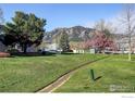 A view of the shared community lawn, mature shade trees, and beautiful mountain views at 1120 Monroe Dr # A, Boulder, CO 80303