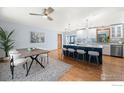 Bright kitchen with stainless appliances, an island with seating, and an adjacent dining area with modern decor at 11382 Flatiron Dr, Lafayette, CO 80026