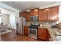 Well-equipped kitchen featuring granite countertops, stainless steel appliances, and warm wood cabinetry at 1358 14Th Ave, Longmont, CO 80501
