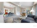 Bright living room with neutral tones, plush seating, and an open layout that flows into the dining area at 1441 Auburn Ct, Longmont, CO 80503