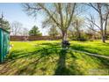 Spacious backyard featuring a well-maintained lawn and mature trees at 1542 Kilkenny St, Boulder, CO 80303