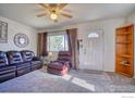 Comfortable living room featuring a plush leather sofa, ceiling fan, and ample natural light at 1709 9Th Ave, Longmont, CO 80501