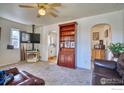 Cozy living room featuring a TV, fireplace, hardwood bookcase, and open access to other rooms at 1709 9Th Ave, Longmont, CO 80501