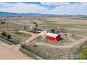 Aerial view showcasing the house with a red outbuilding and the expansive surrounding land at 1916 W County Road 6, Berthoud, CO 80513