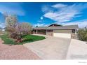 Charming home featuring a lush green lawn, mature trees, and an attached two-car garage at 1916 W County Road 6, Berthoud, CO 80513