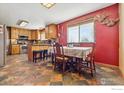 Kitchen and dining area featuring custom cabinets, tile floor, and red accent wall at 1916 W County Road 6, Berthoud, CO 80513