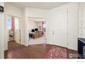 Inviting entryway with hardwood floors, a white front door, and views into the office and other rooms at 24222 E Canyon Pl, Aurora, CO 80016