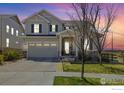 Charming two-story home featuring stone accents, a well-manicured lawn, and inviting front porch at 24222 E Canyon Pl, Aurora, CO 80016