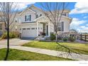 Charming two-story home with manicured lawn, a covered porch, stone accents, and a two-car garage at 24222 E Canyon Pl, Aurora, CO 80016
