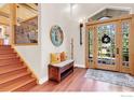 Spacious foyer with hardwood floors, staircase, wooden bench, and a decorative mirror at 2790 Juilliard St, Boulder, CO 80305