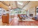 Bright living room featuring a stone fireplace, wood floors, skylights, and vaulted wood ceilings at 2790 Juilliard St, Boulder, CO 80305