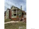 View of the green townhome highlighting its multiple balconies, stairs, and well-maintained lawn at 3025 Broadway St # 17, Boulder, CO 80304
