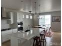Modern kitchen featuring white cabinets, a center island with seating, and stainless steel appliances at 3672 Outcrop Ct, Castle Rock, CO 80108