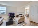 Comfortable living room with fireplace, hardwood floors, and an open doorway to the dining area at 3752 Red Deer Trl, Broomfield, CO 80020