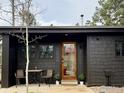 Charming home featuring sleek dark siding, a wooden door, and a cozy outdoor seating area on the front patio at 501 Main St, Boulder, CO 80302