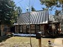 Quaint log cabin featuring a metal roof, a covered porch, and a mailbox at 501 Main St, Boulder, CO 80302
