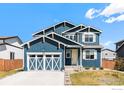 Charming blue two-story home with a two-car garage and well-manicured lawn on a beautiful sunny day at 540 Marmalade Dr, Berthoud, CO 80513