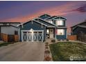Charming two-story home with a blue exterior, well-manicured lawn, and inviting front porch at 540 Marmalade Dr, Berthoud, CO 80513