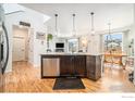 An open-concept kitchen features a dark island, stainless steel appliances, and hardwood floors in an inviting space at 540 Marmalade Dr, Berthoud, CO 80513
