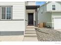 Front door with grey trim and landscaping at 5881 Red Barn Ave, Mead, CO 80504