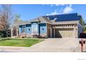 Attractive home with solar panels, a two-car garage, and well-maintained lawn at 6263 Torrey Ln, Arvada, CO 80403
