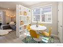 Cozy dining area with a round table, stylish yellow chairs, and a shelving unit for storage and display at 655 Stonebridge Dr, Longmont, CO 80503