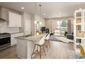 Modern kitchen with stainless steel appliances, white cabinetry, granite countertops, and a convenient breakfast bar at 655 Stonebridge Dr, Longmont, CO 80503