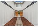 Modern home entrance with a wood accent wall and symmetrical walkway at 7102 S Harrison Ct, Centennial, CO 80122