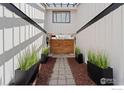 Inviting walkway featuring modern planters that lead to a charming wooden gate at 7102 S Harrison Ct, Centennial, CO 80122