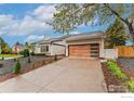 A single-story home with a modern wooden garage door and mature trees at 7102 S Harrison Ct, Centennial, CO 80122
