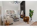 Bright living room with a fireplace, large windows and modern furniture at 7102 S Harrison Ct, Centennial, CO 80122