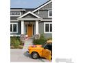 Stylish home exterior with a vibrant yellow door, well-kept landscaping, and a classic car at 7531 Spring Dr, Boulder, CO 80303