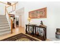 Elegant foyer with hardwood floors, staircase, and decorative console table at 9506 Yukon St, Westminster, CO 80021
