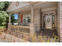 Inviting front porch with brick columns, wooden railing, and covered entrance at 9506 Yukon St, Westminster, CO 80021