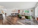 Spacious living room with hardwood floors, modern furniture, and seamless flow to the dining area at 9601 Sierra Dr, Arvada, CO 80005