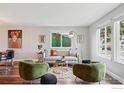 Cozy living room featuring hardwood floors, a stylish couch, and ample natural light from the windows at 9601 Sierra Dr, Arvada, CO 80005